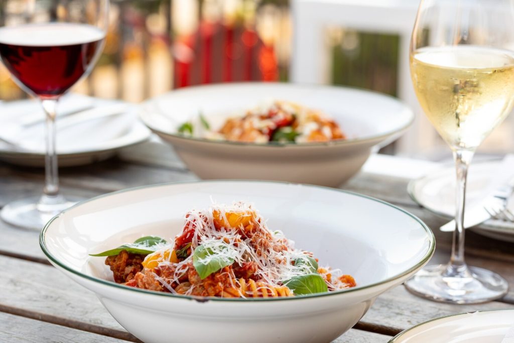 Pasta dishes with red and white wine at a restaurant in Rome