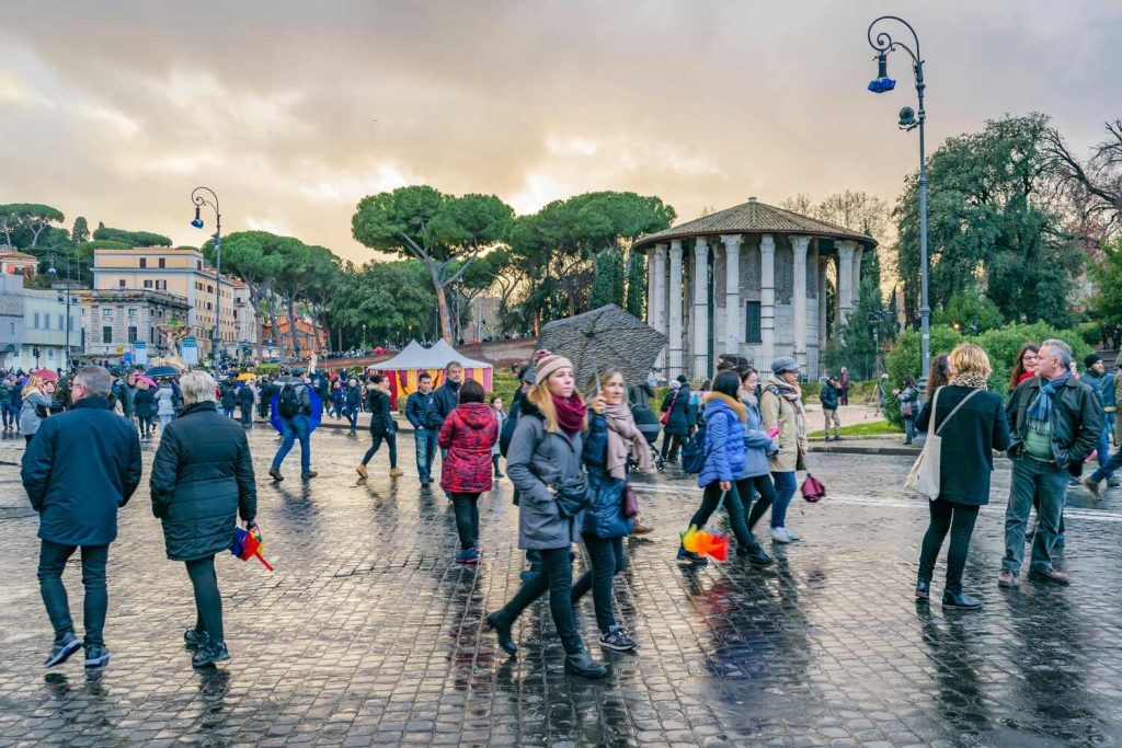 People in busy Roman square, wet day in Rome in February