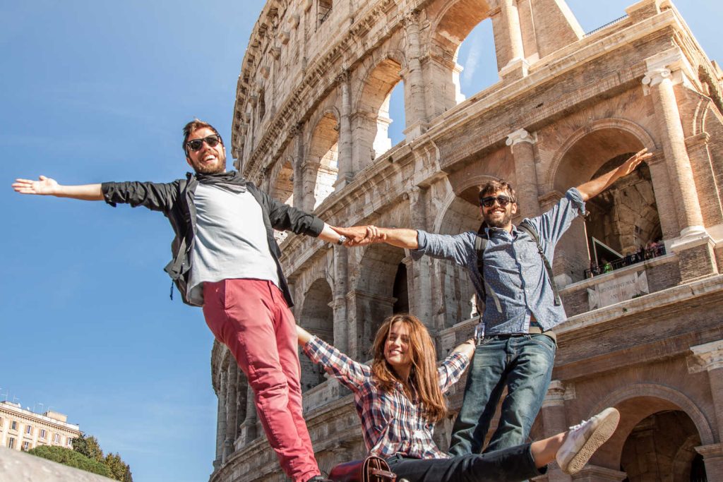 Tour guides posing for a photo in front of the Colosseum in Rome