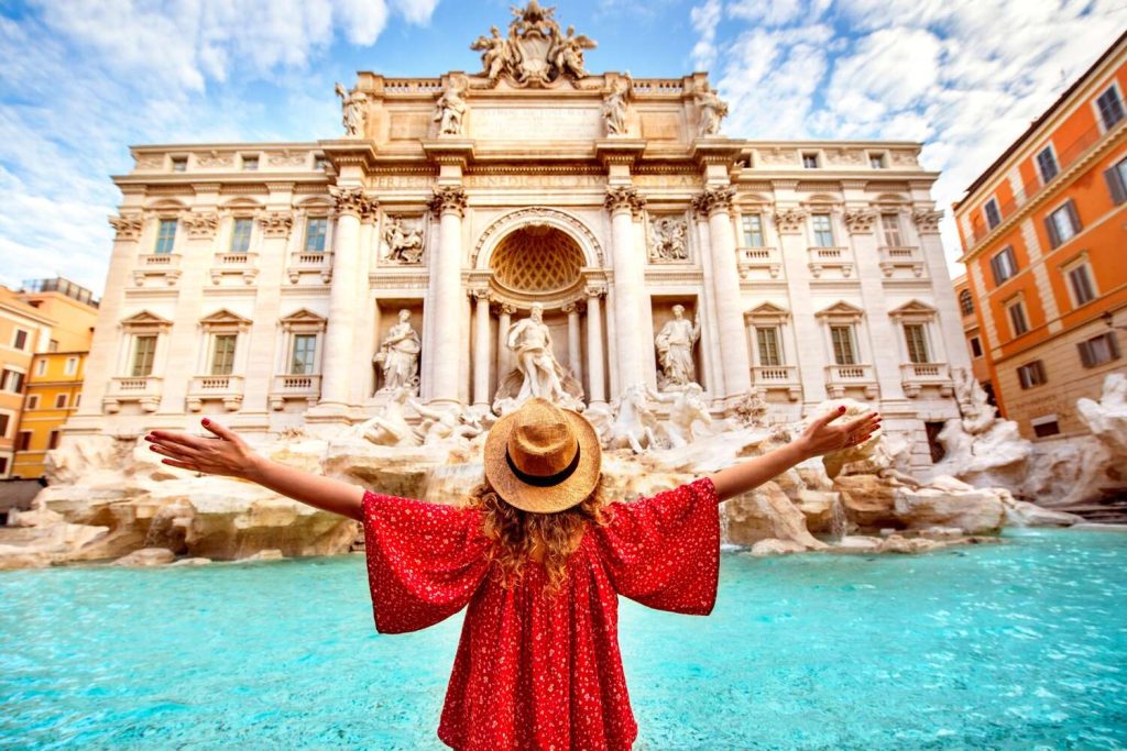 vrouw poseert bij de Trevifontein op een heldere dag in Rome